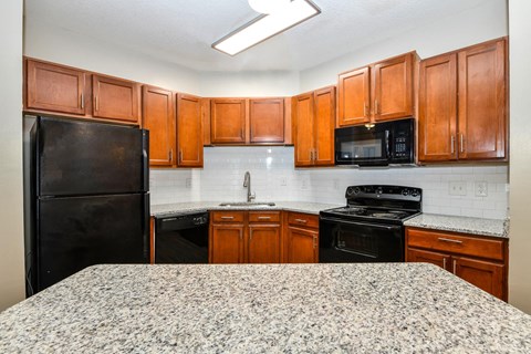 a kitchen with granite counter tops and black appliances